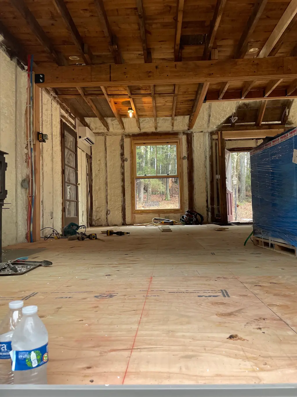 A stud wall and rafter bays filled with cured closed-cell spray foam